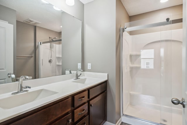 bathroom with a shower with door and vanity