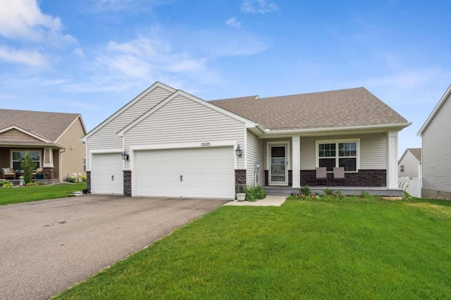 view of front facade featuring a front yard, driveway, covered porch, a shingled roof, and a garage