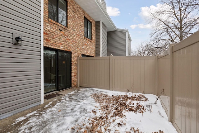 snow covered patio featuring fence