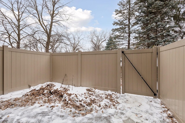 snow covered gate featuring fence