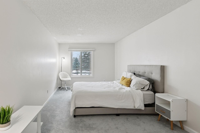 bedroom featuring carpet flooring, baseboards, and a textured ceiling