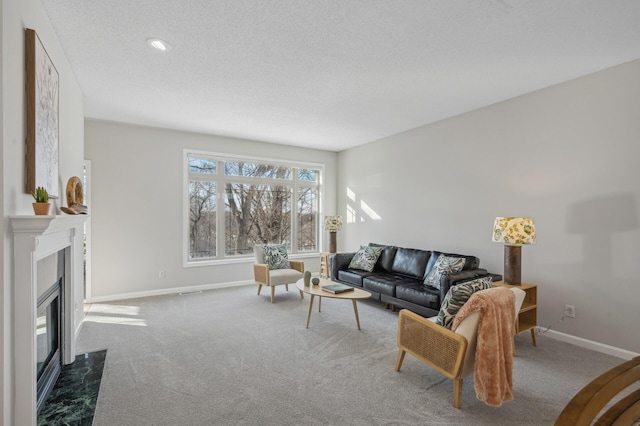 living area with carpet, a premium fireplace, baseboards, and a textured ceiling