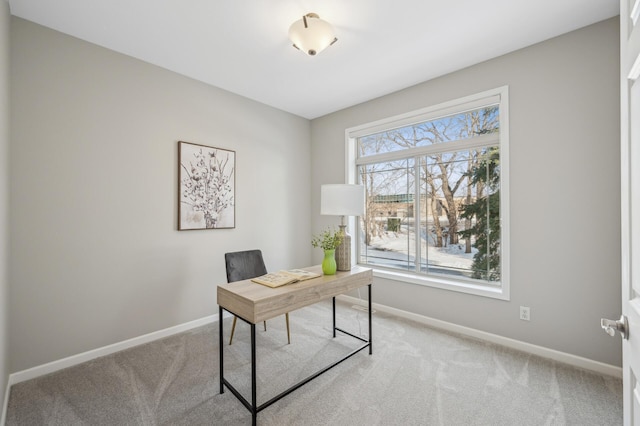 office space featuring light carpet and baseboards