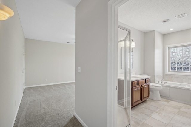 bathroom with a garden tub, visible vents, toilet, vanity, and baseboards