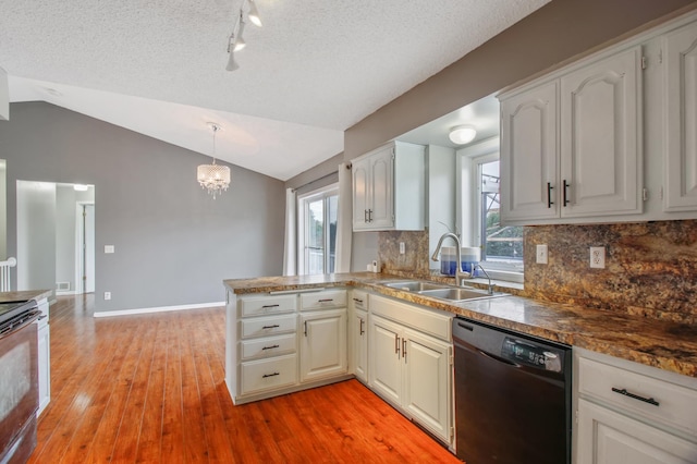 kitchen featuring lofted ceiling, sink, electric range, black dishwasher, and decorative light fixtures