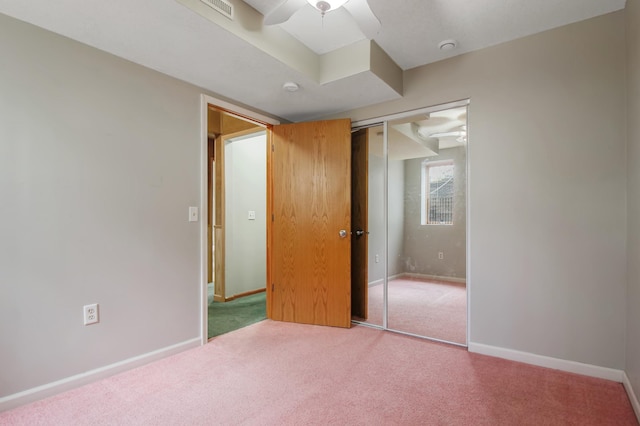 unfurnished bedroom with a closet, ceiling fan, and carpet flooring