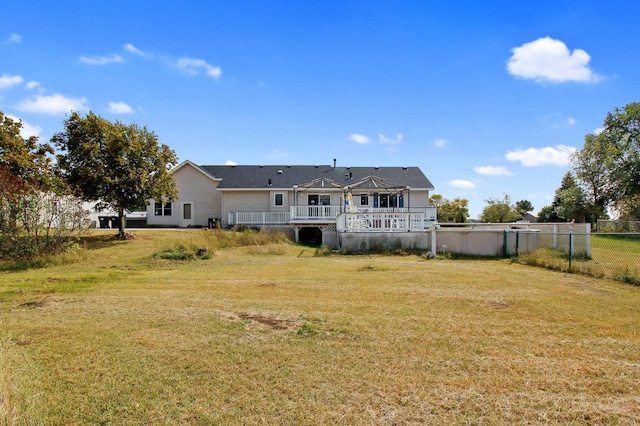 rear view of house featuring a yard and a deck