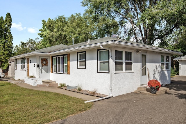 ranch-style house with a front lawn and stucco siding