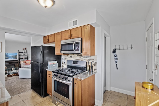 4812-4814 Idaho Ave N, Crystal, MN 55428 - kitchen featuring stainless steel appliances, light tile patterned floors, tasteful backsplash, and light stone counters