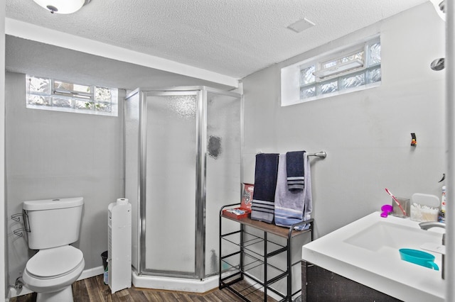 4812-4814 Idaho Ave N, Crystal, MN 55428 - full bathroom with a textured ceiling, a shower stall, wood finished floors, and toilet