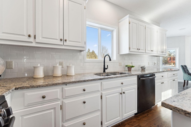 kitchen featuring dishwashing machine, dark wood-style flooring, light stone countertops, white cabinetry, and a sink