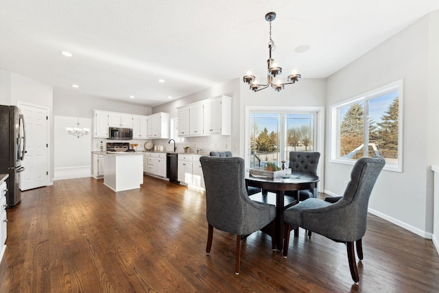 dining space featuring a chandelier, baseboards, and dark wood-style floors