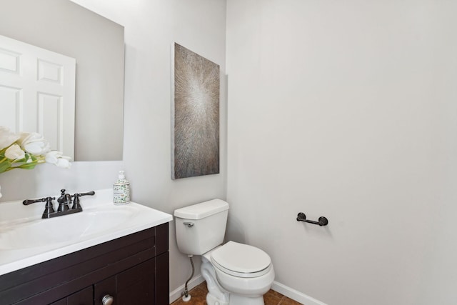 bathroom with toilet, tile patterned flooring, vanity, and baseboards