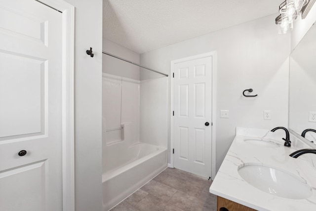 full bathroom featuring bathing tub / shower combination, a sink, a textured ceiling, and double vanity