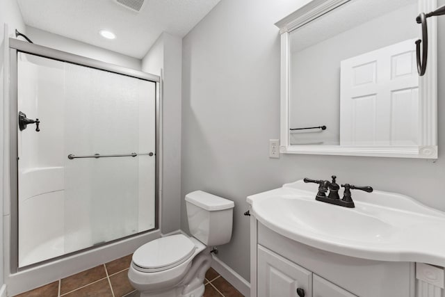 full bath featuring vanity, a shower with door, toilet, and tile patterned floors