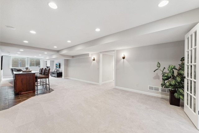 interior space with a breakfast bar, a center island, recessed lighting, visible vents, and open floor plan