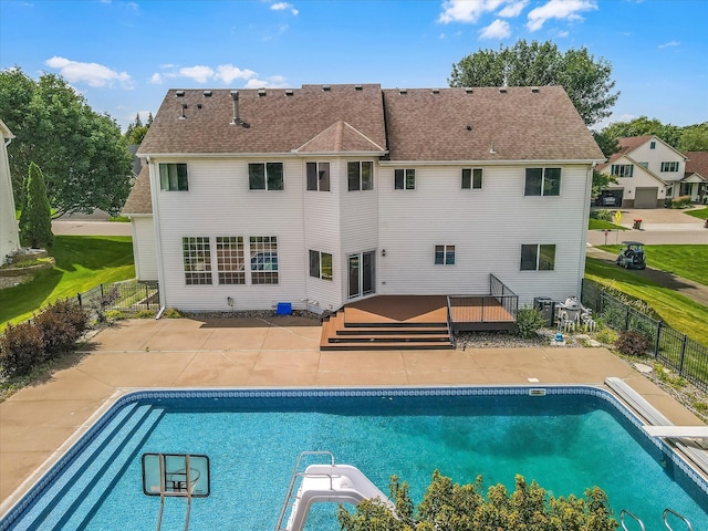 view of swimming pool featuring a diving board, fence, a deck, and a fenced in pool