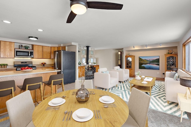 dining area with a wood stove, rail lighting, recessed lighting, and ceiling fan