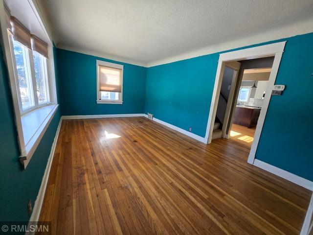 spare room with hardwood / wood-style floors and a textured ceiling