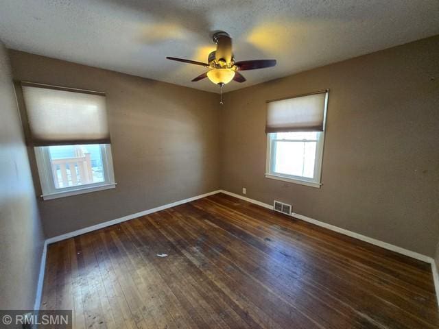 spare room featuring dark hardwood / wood-style flooring and ceiling fan