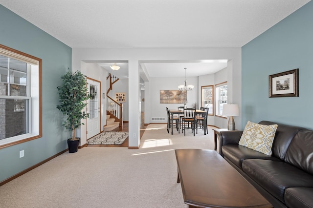 living room featuring light colored carpet and a notable chandelier