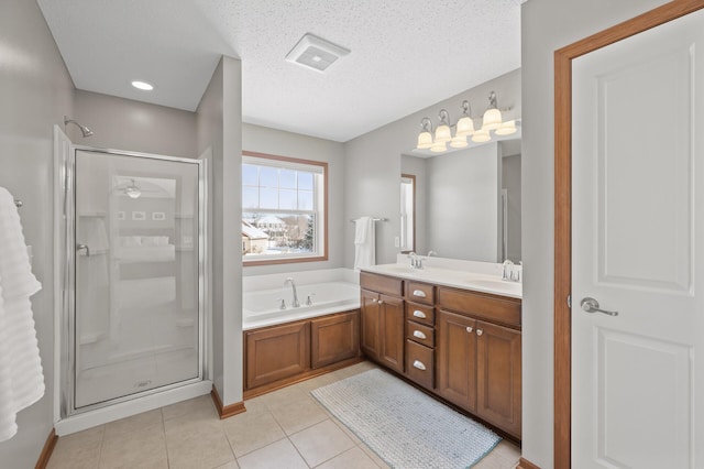 bathroom with vanity, tile patterned floors, plus walk in shower, and a textured ceiling