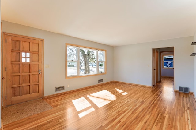 foyer entrance with visible vents, baseboards, and light wood-style floors