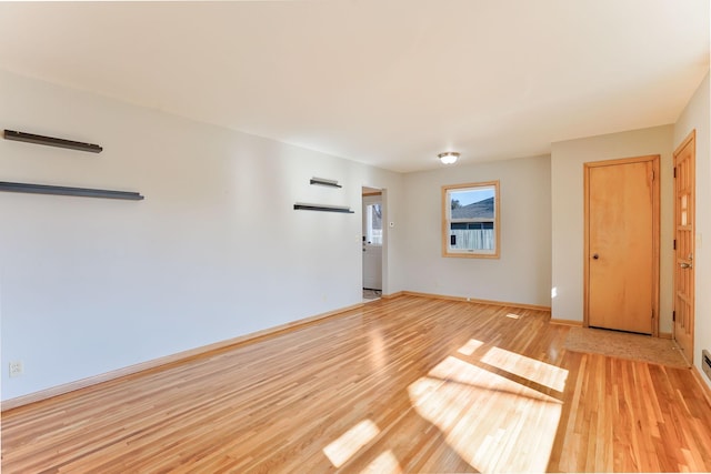 empty room with light wood finished floors and baseboards