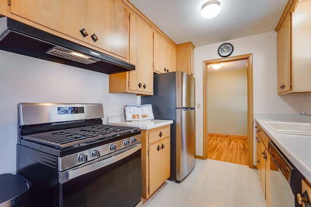 kitchen featuring a sink, light countertops, under cabinet range hood, and stainless steel appliances