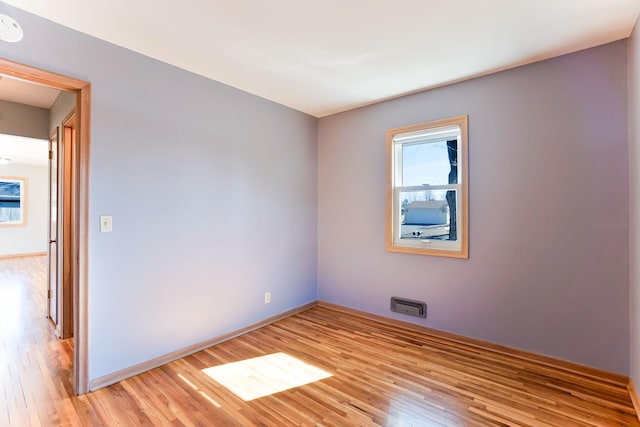 empty room featuring baseboards and light wood-style floors