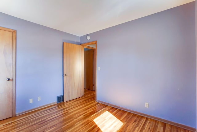 spare room with visible vents, light wood-type flooring, and baseboards