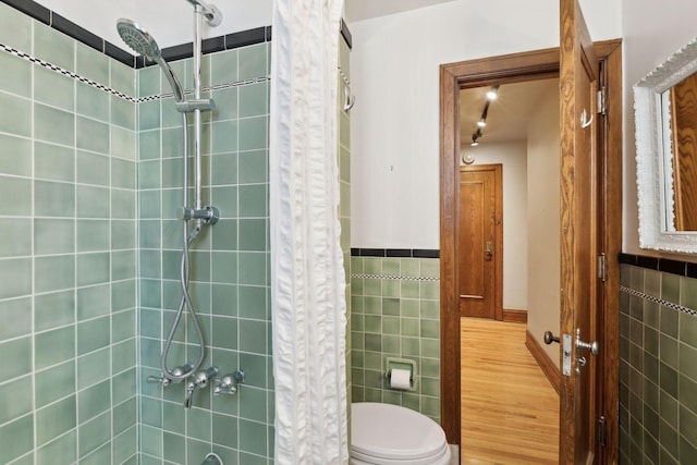 bathroom featuring tile walls and toilet