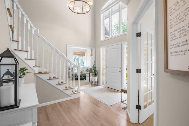 entryway featuring a chandelier, hardwood / wood-style floors, and a high ceiling