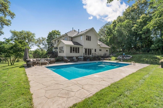 view of pool with a patio, outdoor lounge area, and a lawn