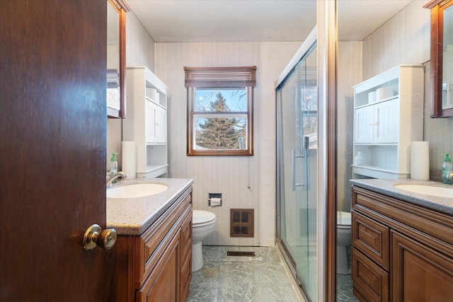 bathroom with toilet, a shower stall, visible vents, and vanity