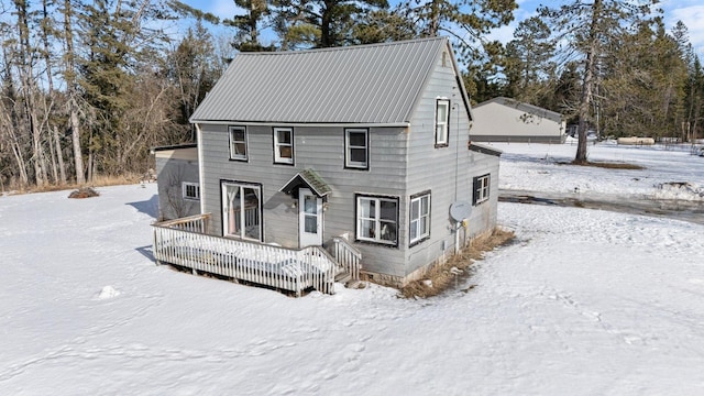 view of front of property with a garage, metal roof, and a wooden deck