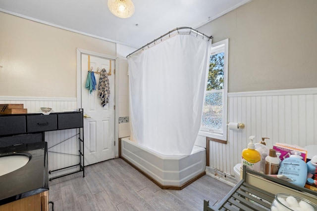 bathroom with a wainscoted wall, plenty of natural light, and wood finished floors