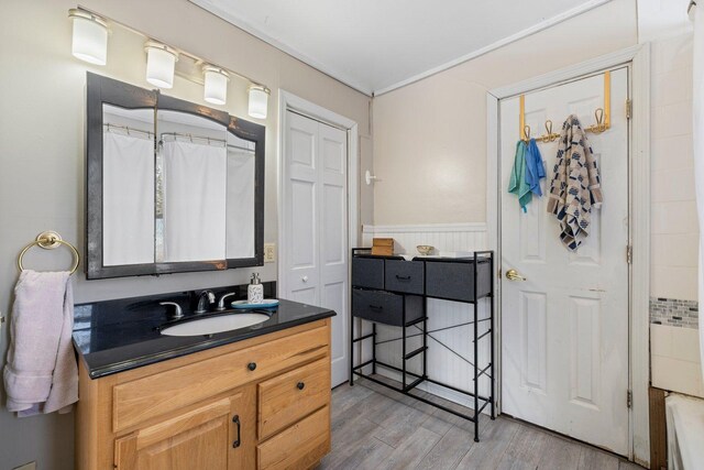 bathroom featuring a wainscoted wall, a shower with shower curtain, wood finished floors, and vanity