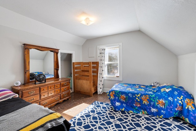 bedroom with vaulted ceiling and wood finished floors