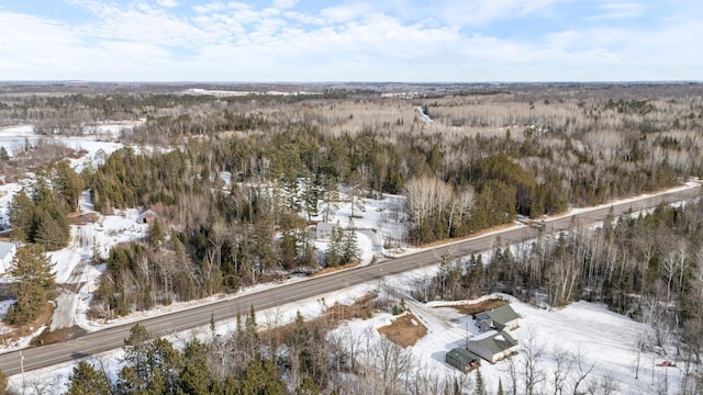 snowy aerial view with a wooded view