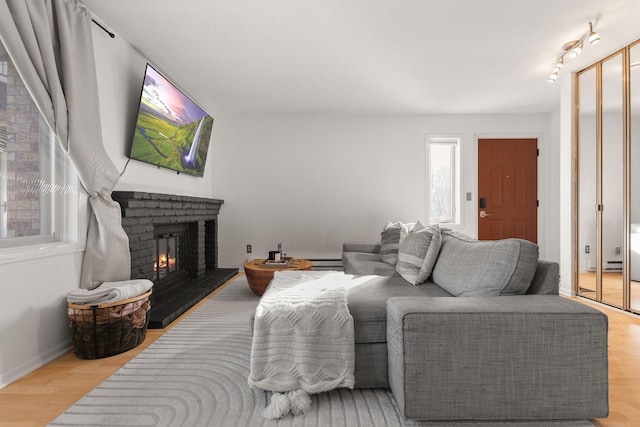 living room with a fireplace, wood finished floors, and baseboards