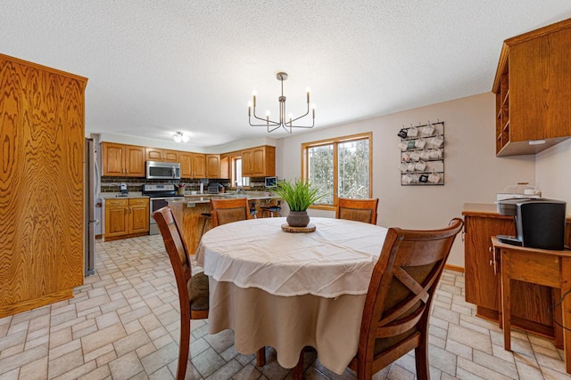 dining area with a notable chandelier and a textured ceiling