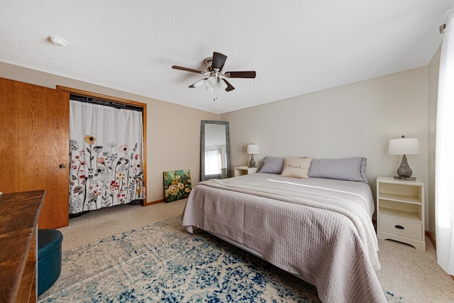 bedroom featuring ceiling fan, carpet floors, and a textured ceiling