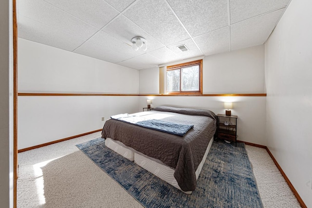 carpeted bedroom with a drop ceiling