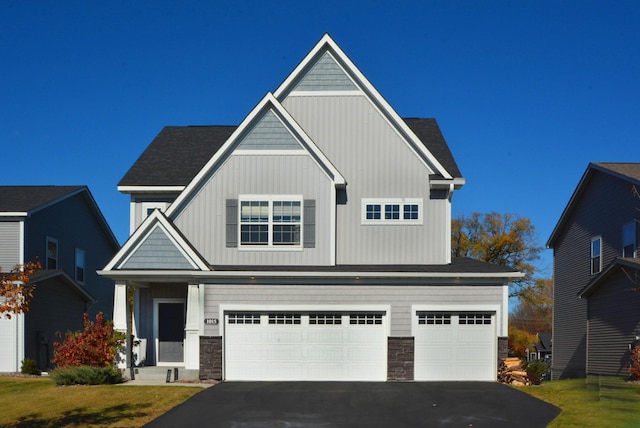 craftsman inspired home with a garage and a front yard