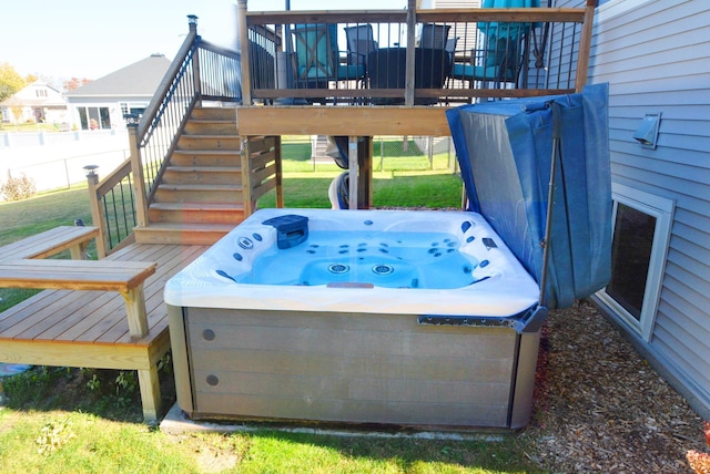 wooden terrace featuring a hot tub and a lawn