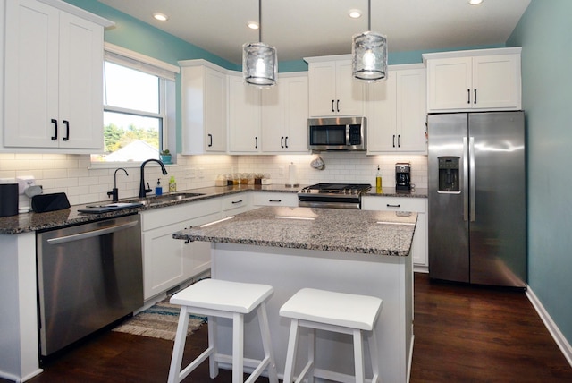 kitchen with white cabinetry, a kitchen island, and appliances with stainless steel finishes