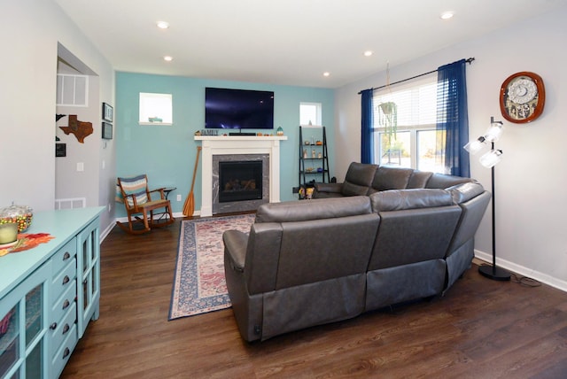 living room with dark wood-type flooring and a premium fireplace