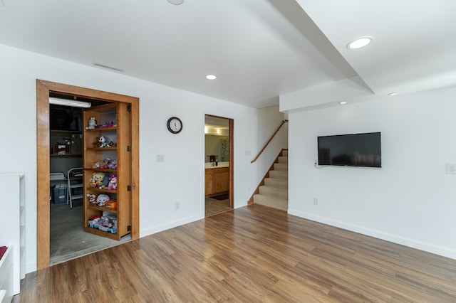 5078 Nicklaus Dr NW, Rochester, MN 55901 - unfurnished living room with stairs, wood finished floors, and recessed lighting