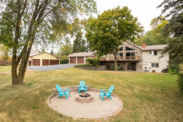 view of yard with an outbuilding, a patio area, a garage, a fire pit, and a wooden deck